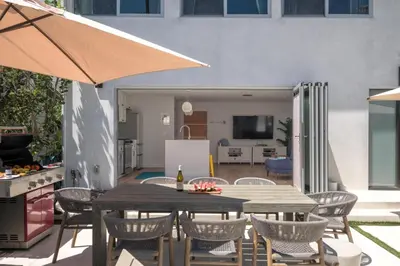 a patio with a table and chairs and a kitchen at Your Coastal Getaway in Manhattan Beach Awaits in Manhattan Beach