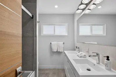 a white bathroom with a sink and a mirror at Your Coastal Getaway in Manhattan Beach Awaits in Manhattan Beach