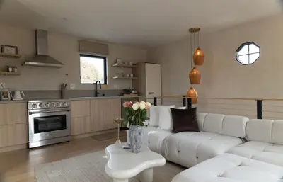 a living room with a white couch and a kitchen at Luxe 2BR with Designer Touches, Walk to Everything in Los Angeles