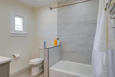 a white bathroom with a shower and a toilet at Walk to Dtwn Tehachapi Updated Getaway with Yard! in Tehachapi