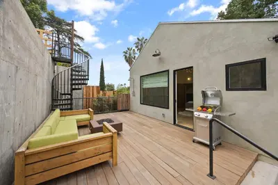 a backyard deck with a couch and a grill at New Listing Hillside Villa by Colby & Conrad in Los Angeles