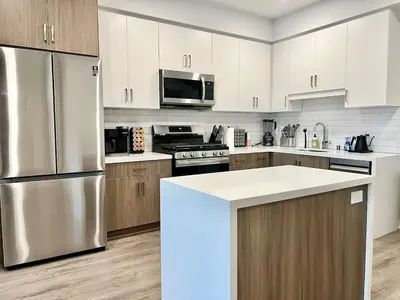 a kitchen with a stainless steel refrigerator and wooden cabinets at Designer 1 Bedroom Condo in Silver Lake in Los Angeles