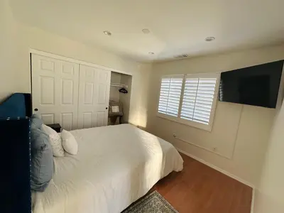 a bedroom with a white bed and a flat screen tv at Echo House in Los Angeles