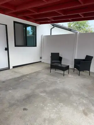 a patio with two black chairs and a window at Guesthouse in Hewitt