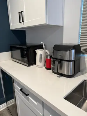 a kitchen counter with a microwave and a coffee maker at Guesthouse in Hewitt