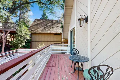 a balcony with a table and chairs on a house at Bright Moon in Lake Arrowhead