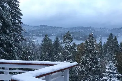 a snow covered balcony with a view of a lake at Bright Moon in Lake Arrowhead