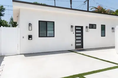 a white house with a black door at New 2BR Family Home Nr Universal in Gemco