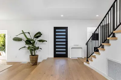 a hallway with a black door and a potted plant at Villa Incanto in Los Angeles