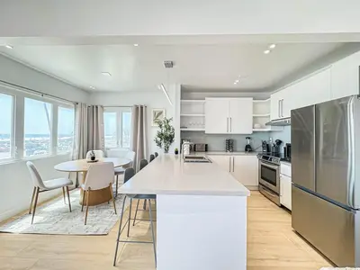 a kitchen with white cabinets and a table with chairs at Seaside 2BR with Ocean View and Roof Garden - VE3-MDR in Los Angeles