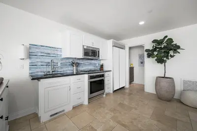 a kitchen with white cabinets and a potted plant at Ocean Views in Long Beach in Long Beach