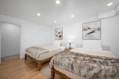 two beds in a room with white walls at Ocean Views in Long Beach in Long Beach