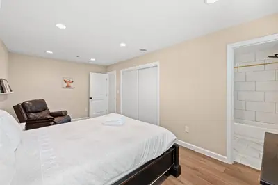 a white bedroom with a bed and a chair at Heartwarming Family Stay 10 Min Walk to Pomona Valley Hospital in Pomona