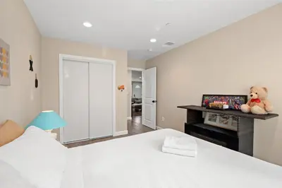 a bedroom with a white bed and a teddy bear on a shelf at Heartwarming Family Stay 10 Min Walk to Pomona Valley Hospital in Pomona