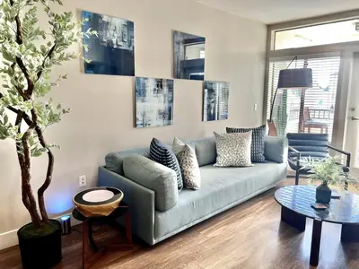 a living room with a blue couch and a table at Designer 2 Bedroom with 3 Beds- Pool View, Gym, Parking in Los Angeles