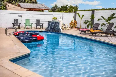a swimming pool with an inflatable raft in a backyard at Stylish 5 Bedroom Villa with Pool near Disney - Luxury Family Retreat in Anaheim