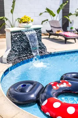 a pool with two inflatables in front of a fountain at Stylish 5 Bedroom Villa with Pool near Disney - Luxury Family Retreat in Anaheim