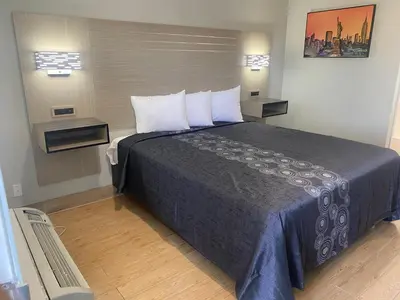 a bedroom with a large bed with two pillows at Mayfair Inn Onratio Airport & Convention Center in Ontario
