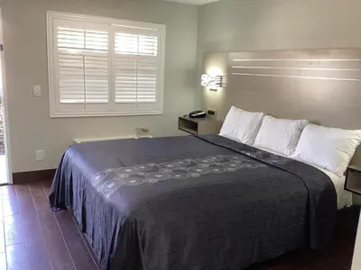 a hotel room with a large bed with a window at Mayfair Inn Onratio Airport & Convention Center in Ontario