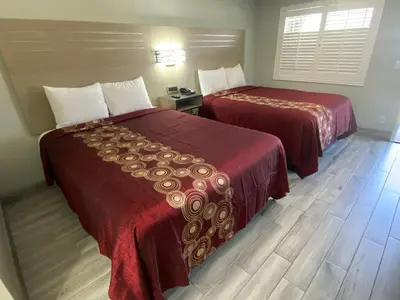 two beds in a hotel room next to each other at Mayfair Inn Onratio Airport & Convention Center in Ontario