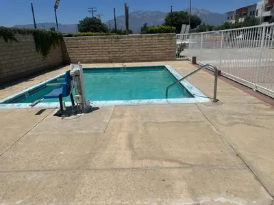 an empty swimming pool with a ramp in a building at Mayfair Inn Onratio Airport & Convention Center in Ontario