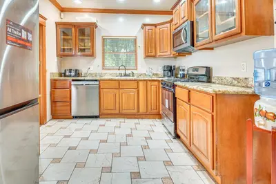 a kitchen with wooden cabinets and stainless steel appliances at 2 Mi to USC Central Home in Los Angeles! in Los Angeles
