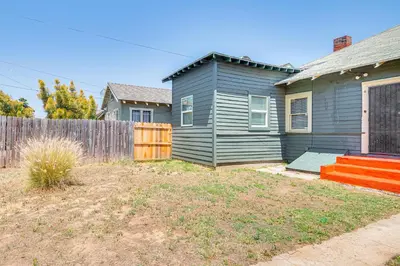a gray house with a fence in a yard at 2 Mi to USC Central Home in Los Angeles! in Los Angeles