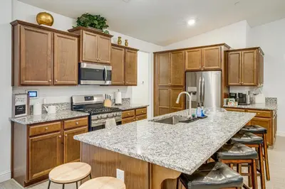 a kitchen with wooden cabinets and a granite counter top at 9 Mi to Dtwn Bakersfield Pet-Friendly Home in Bakersfield