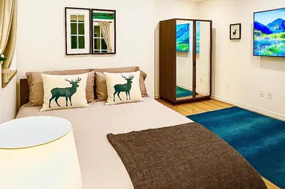 a living room with a couch with two deer pillows at Enchanting Private Hollywood Hills Guest House with Tranquil Tree-Top Views, Magical Outdoor Living Room and Patio and Zen Garden, In LA's Most Desirable, Central, Serene Area and Only 2 Minutes from Hollywood Boulevard in Los Angeles