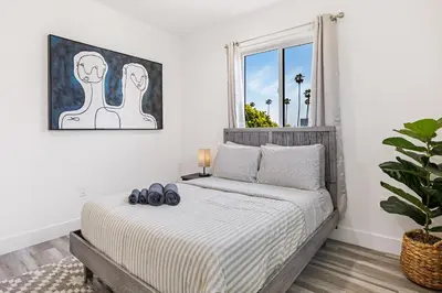 a bedroom with a bed with blue shoes on it at Sophisticated Getaway Hollywood & Dtla in Los Angeles
