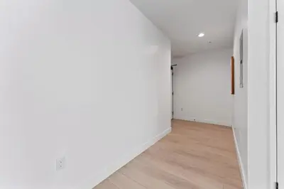 an empty hallway with white walls and wooden floors at Stylish LA studio Prime Location in Los Angeles