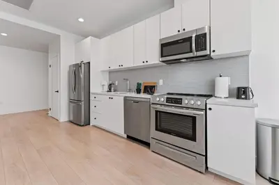 a kitchen with stainless steel appliances and white cabinets at Stylish LA studio Prime Location in Los Angeles