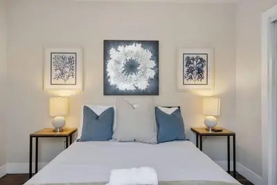a bedroom with a bed with blue pillows and two lamps at Travel Haven - Great Location - Quiet Area in Long Beach