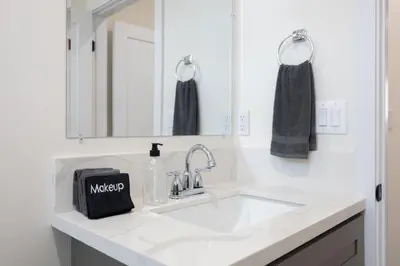 a white bathroom with a sink and a mirror at Contemporary Retreat Hollywood & DTLA in Los Angeles