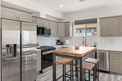 a kitchen with stainless steel appliances and a wooden island at Contemporary Retreat Hollywood & DTLA in Los Angeles