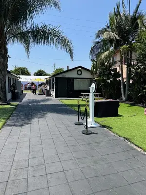 a concrete walkway with a park with palm trees at LUXURY VILLA Estate Oasis in Downey