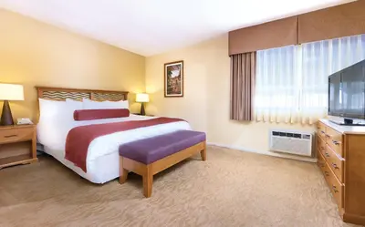 a hotel room with a bed and a television at Wyndham Dolphin's Cove 1BR Suite with Resort Access in Anaheim