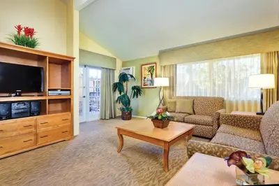 a living room with a couch and a tv at Wyndham Dolphin's Cove 1BR Suite with Resort Access in Anaheim