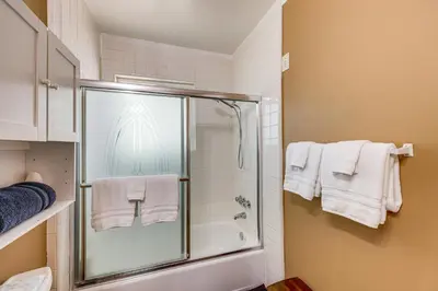 a bathroom with a shower and a bath tub with towels at Between Big Bear and Lake Arrowhead - Cabin with View! in Running Springs