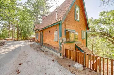 a small wooden house with a fence next to a road at Between Big Bear and Lake Arrowhead - Cabin with View! in Running Springs
