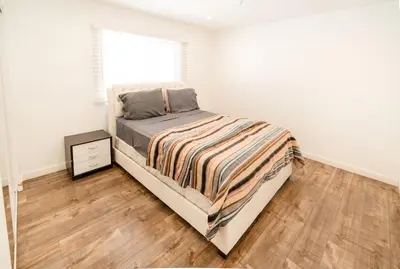 a bedroom with a bed and a wooden floor at Cozy Stylish 1-Bedroom In Hollywood With Free Gated Parking in Los Angeles
