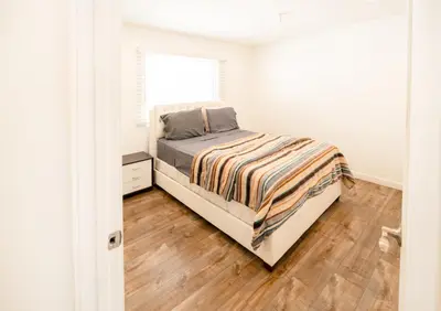 a bedroom with a bed and a wooden floor at Cozy Stylish 1-Bedroom In Hollywood With Free Gated Parking in Los Angeles