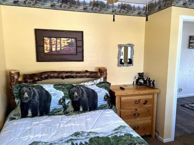 two bears standing on a bed in a bedroom at Best View of the Lake! Huge Deck! in Crestline