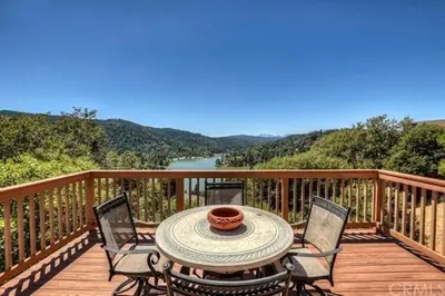 a table and chairs on a wooden deck with a view at Best View of the Lake! Huge Deck! in Crestline