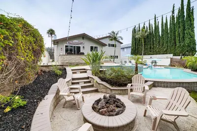 a patio with chairs and a fire pit next to a pool at Golf, Swim, Relax Family Retreat in Corona! in Corona