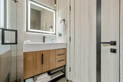 a bathroom with a sink and a mirror at The Valley Nest Backyard Gameroom in Los Angeles