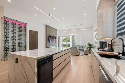 a large kitchen with a counter top and a living room at The Valley Nest Backyard Gameroom in Los Angeles