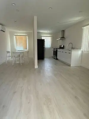 an empty room with a kitchen and a table in it at San Marino guest house in Los Angeles