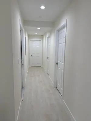 an empty hallway with white walls and white doors at San Marino guest house in Los Angeles