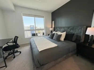 a bedroom with a bed and a desk and a window at Modern 1BR Apartment with Pool, Hot Tub and Gym Access 10mins to Universal Studios in Los Angeles
